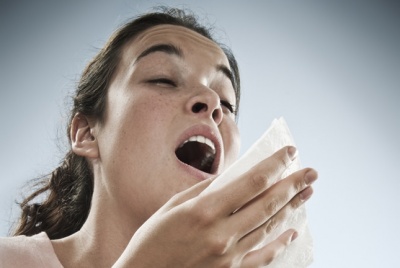 woman sneezing because of allergies from dirty mattress